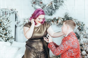 Homosexual gay butch woman proposing her girlfriend to marry her and giving her box with ring. LGBTQ lesbian couple celebrating Christmas or New Year winter holiday. Real authentic positive emotion