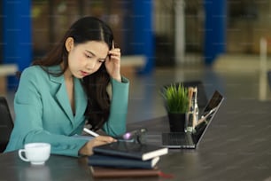 Stressed professional female manager working on her project in the office. Pensive thinking, ponder, thoughtful person.