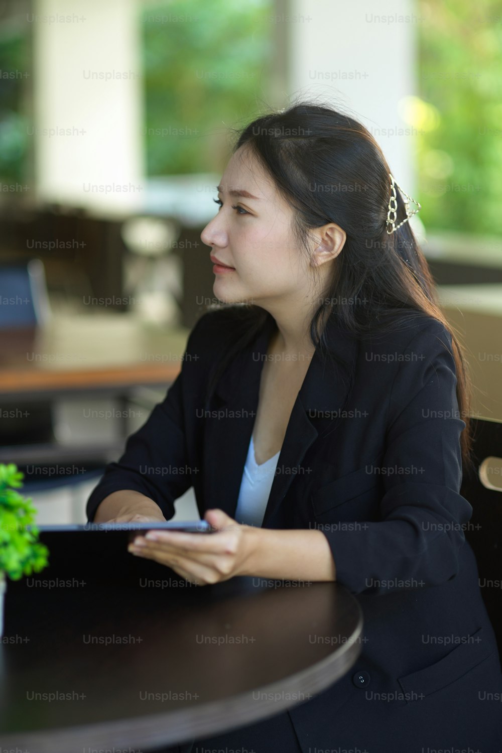 Portrait of a businesswoman sitting at the desk while talking with her business client at coffee shop.