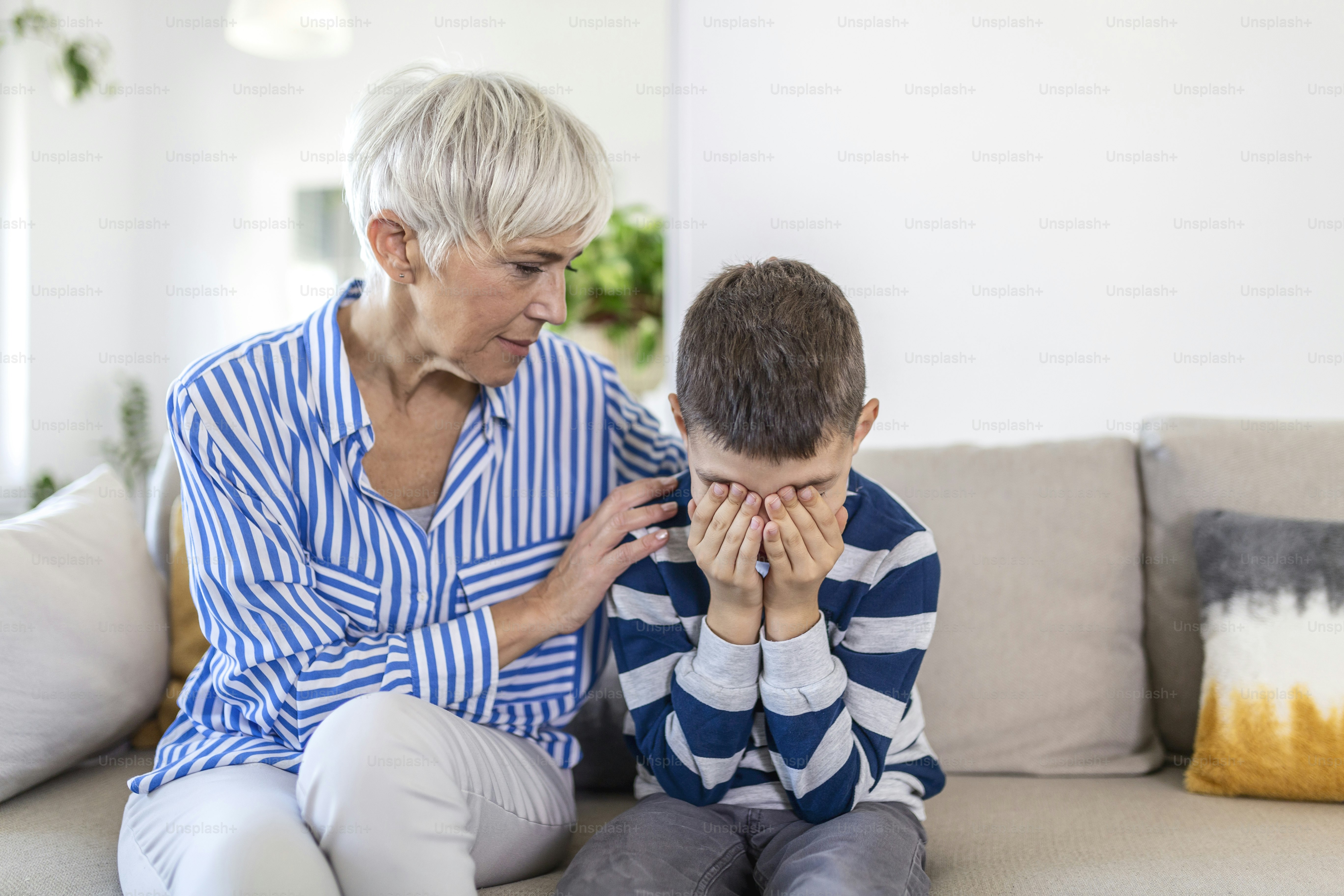 Loving understanding old grandma embracing little crying boy comforting upset grandson, senior caring grandmother hugging child consoling kid in tears, grannys empathy support for grandchild