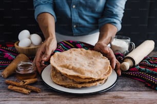 hands of mexican man cooking buñuelos, recipe and ingredients of traditional dessert for Christmas in Mexico