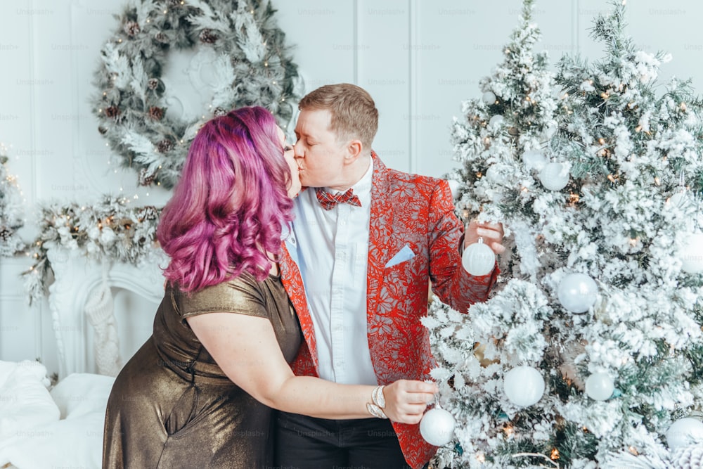 Casal de lésbicas LGBTQ celebrando o Natal ou o feriado de inverno de Ano Novo juntos. Senhora feminina gay com parceiro butch decorando árvore de Natal em casa. Espírito de humor de férias de inverno.