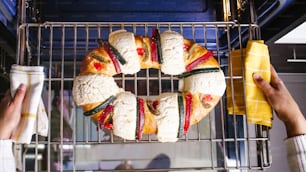 mexican woman baking a traditional rosca de reyes or epiphany cake on the oven in kitchen at home for Kings Day in Mexico Latin America
