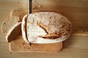 Couper une miche de pain au levain maison avec un couteau, vue de dessus