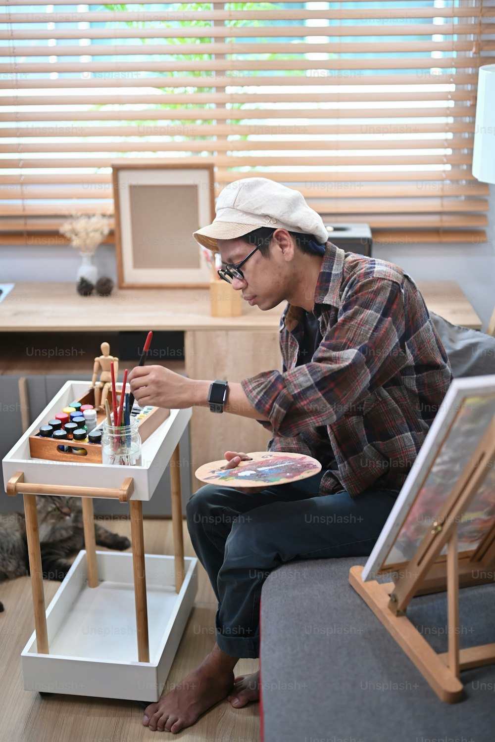 Male artist painting with watercolor at art studio.
