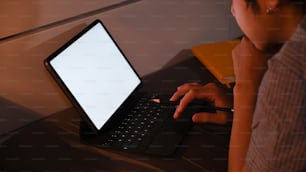 Cropped shot young man lying on comfortable bed and working with computer tablet at late night.