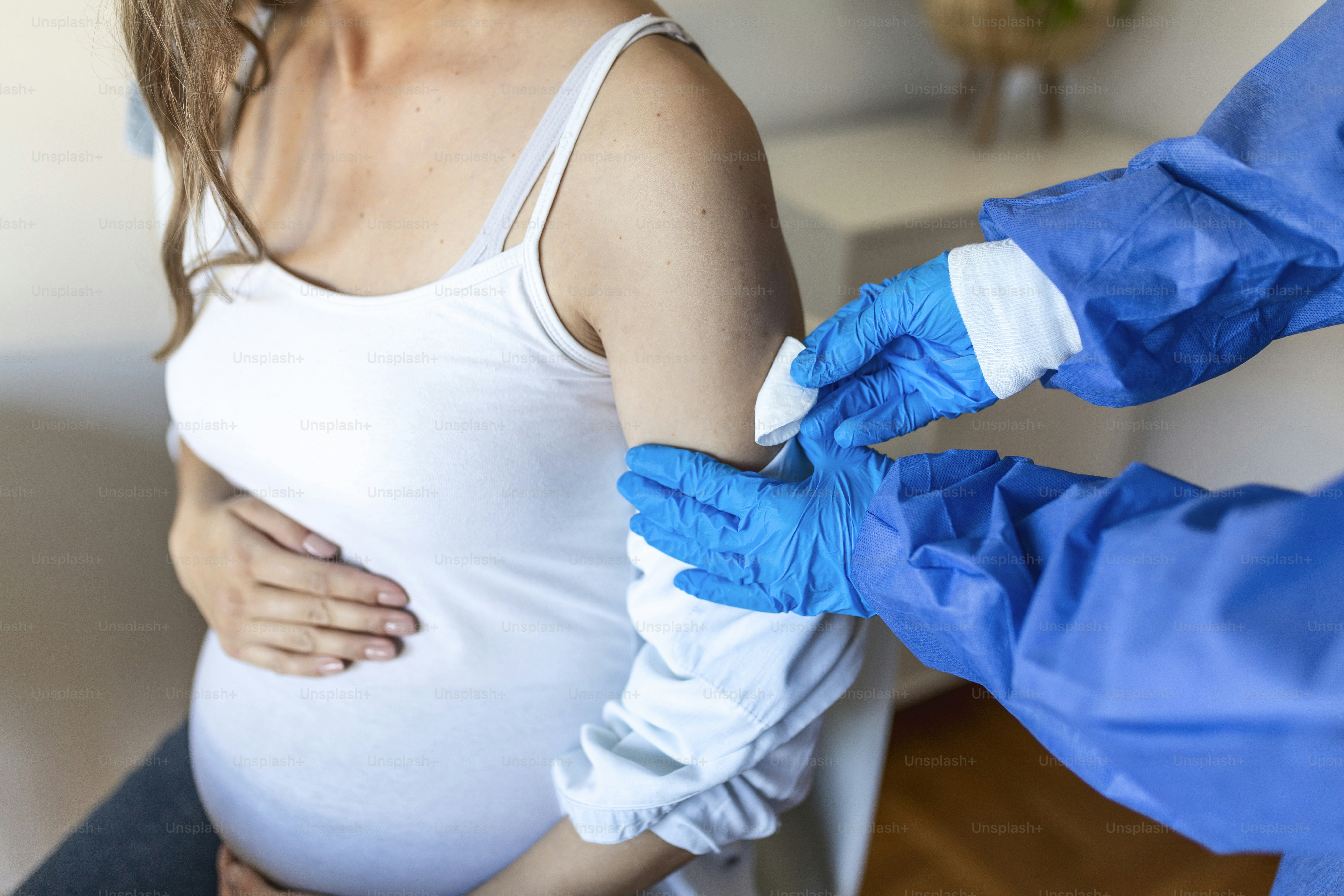Female doctor giving the coronavirus vaccine to a young pregnant woman. Antibodies, immunize population. side effects, risk people, antibodies, new normal, covid-19.