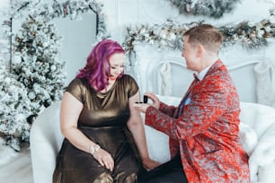 Mulher homossexual gay butch propondo sua namorada para se casar com ela e dando-lhe caixa com anel. Casal de lésbicas LGBTQ celebrando o Natal ou o feriado de inverno de Ano Novo. Emoção positiva autêntica real