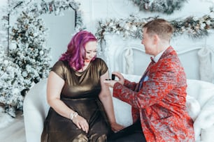 Homosexual gay butch woman proposing her girlfriend to marry her and giving her box with ring. LGBTQ lesbian couple celebrating Christmas or New Year winter holiday. Real authentic positive emotion