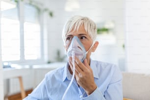 Sick elderly woman on oxygen mask inhalation, pneumonia coronavirus pandemic. ill senior woman wearing an oxygen mask and undergoing treatment. senior woman with covid 19