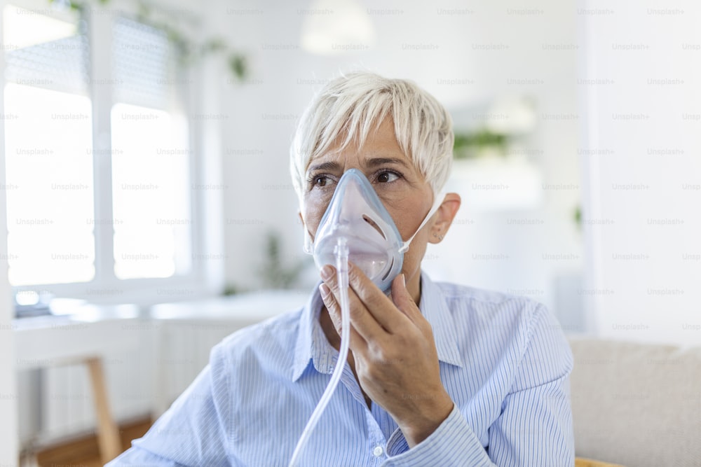 Sick elderly woman on oxygen mask inhalation, pneumonia coronavirus pandemic. ill senior woman wearing an oxygen mask and undergoing treatment. senior woman with covid 19