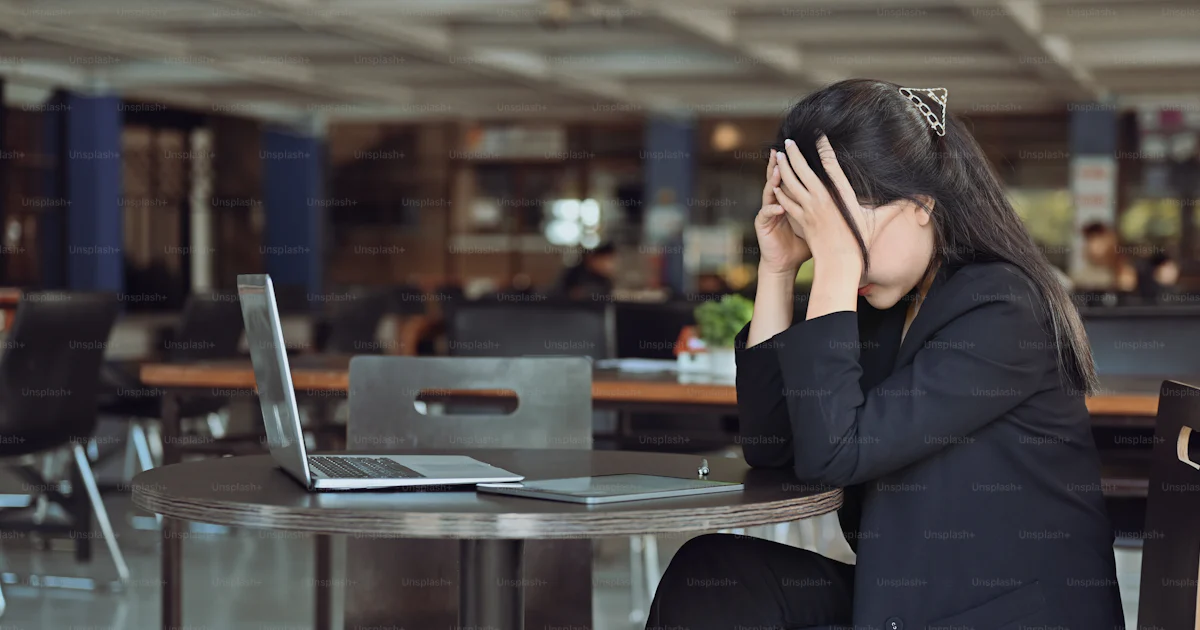 Frustrated business woman felling stress while sitting at her office ...