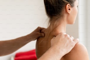 Close up das mãos do homem massagista durante a massagem nas costas para sua cliente mulher