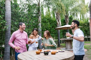 Group of Young latin Friends Meeting For beer, michelada Drinks And mexican Food Making A Toast In Restaurant terrace in Mexico Latin America