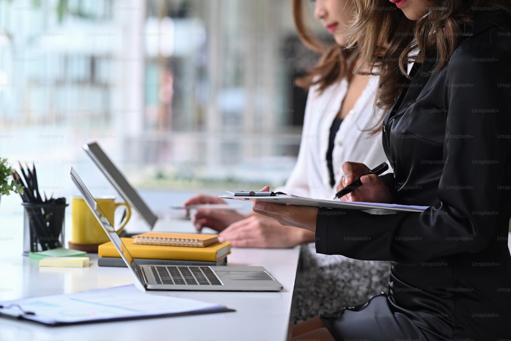 Cropped image of two businesswoman discussing project together.