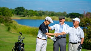 4K Group of Asian people businessman and senior CEO enjoy outdoor sport lifestyle golfing together at golf country club. Healthy men golfer shaking hand after finish the game at golf course on summer vacation