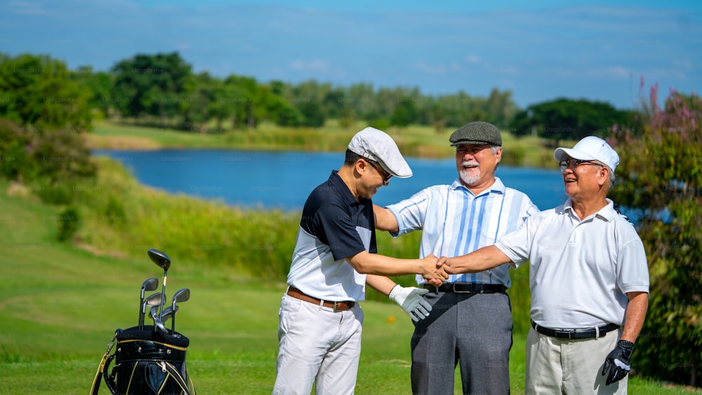 4K Group of Asian people businessman and senior CEO enjoy outdoor sport lifestyle golfing together at golf country club. Healthy men golfer shaking hand after finish the game at golf course on summer vacation