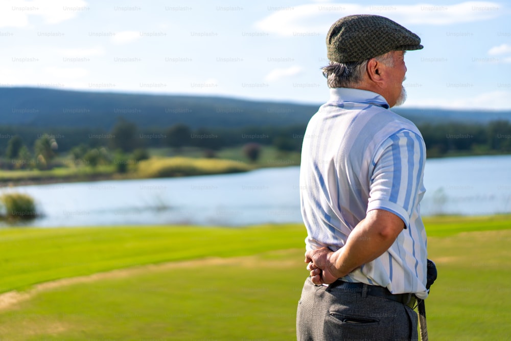 Asian senior man caught his injury back pain while golfing at country club on summer vacation. Elderly male golfer backache while outdoor sport workout. Senior people medical and healthy care concept