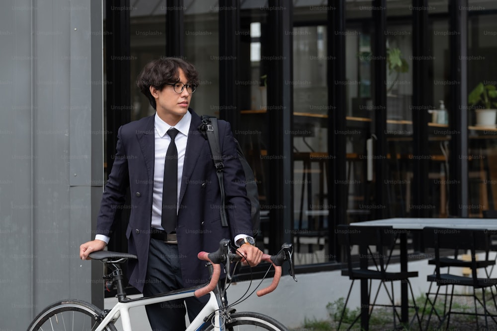 Asian businessman pushing his bicycle in the morning preparing to ride his bicycle to work. Eco transportation.