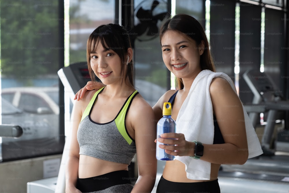 Portrait de deux filles tachetées souriant fitness après s’être entraînées ensemble dans le gymnase