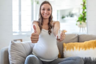 Primer plano de la mano de una mujer embarazada sosteniendo un dispositivo de prueba negativo. Feliz mujer embarazada mostrando su prueba rápida negativa de Coronavirus - Covid-19. Coronavirus