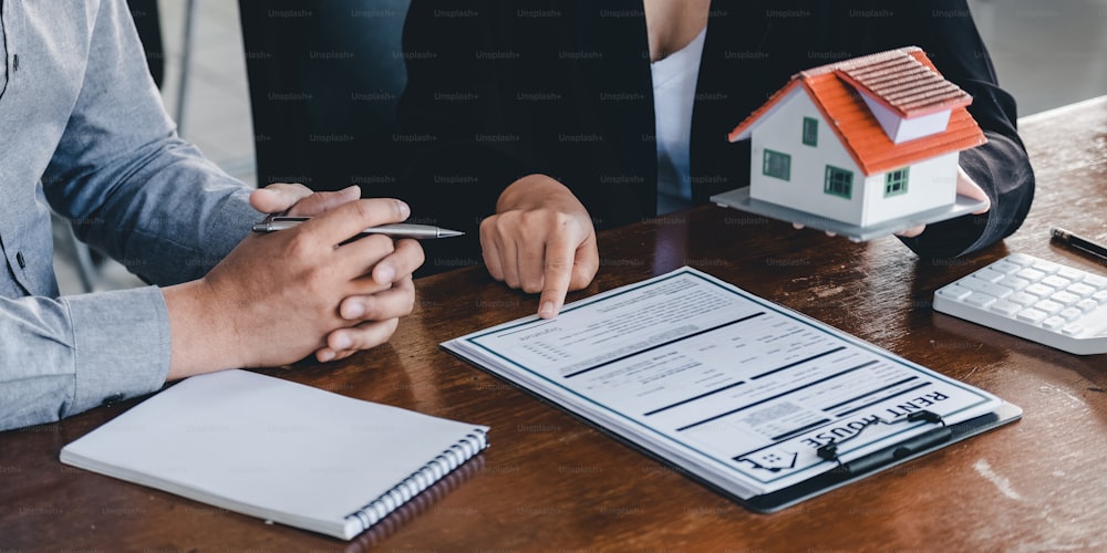 L'agente immobiliare ha parlato dei termini del contratto di acquisto della casa, il cliente firma i documenti per rendere legale il contratto, le vendite di case e il concetto di assicurazione sulla casa.