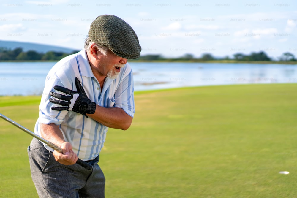 L'uomo anziano asiatico si è infortunato alla spalla mentre giocava a golf al country club durante le vacanze estive. Dolore alla spalla di un golfista maschio anziano durante l'allenamento sportivo all'aperto. Concetto di assistenza medica e sana per le persone anziane