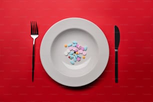 Ergänzungen als Nahrung auf rundem weißen Teller mit Gabel und Messer. Konzept von Vitaminen statt Nahrung.