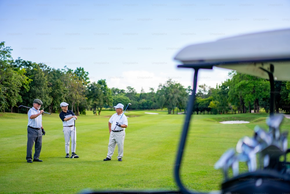 Gruppe asiatischer Menschen Geschäftsmann und Senior CEO genießen Outdoor-Sport Lifestyle Golf zusammen im Golf Country Club. Gesunde Männer Golfer schütteln die Hand nach Beendigung des Gesprächs Geschäftsprojekt und Spiel auf dem Golfplatz