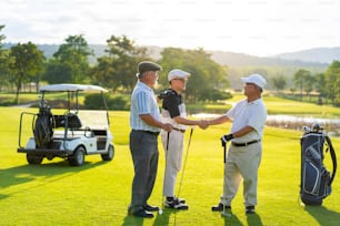 4K Group of Asian people businessman and senior CEO enjoy outdoor sport lifestyle golfing together at golf country club. Healthy men golfer shaking hand after finish the game at golf course on summer vacation