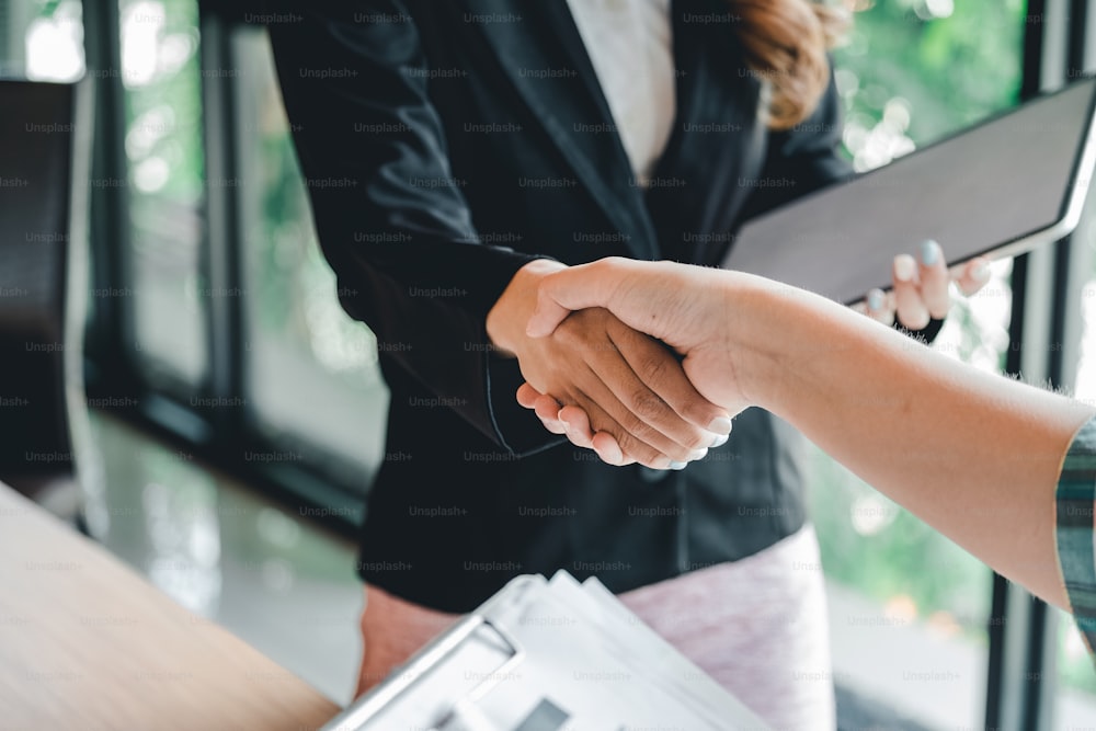 two businessman shake hands as hello in office closeup. Friend welcome, introduction, greet or thanks gesture, product advertisement, partnership approval, strike a bargain on deal concept.