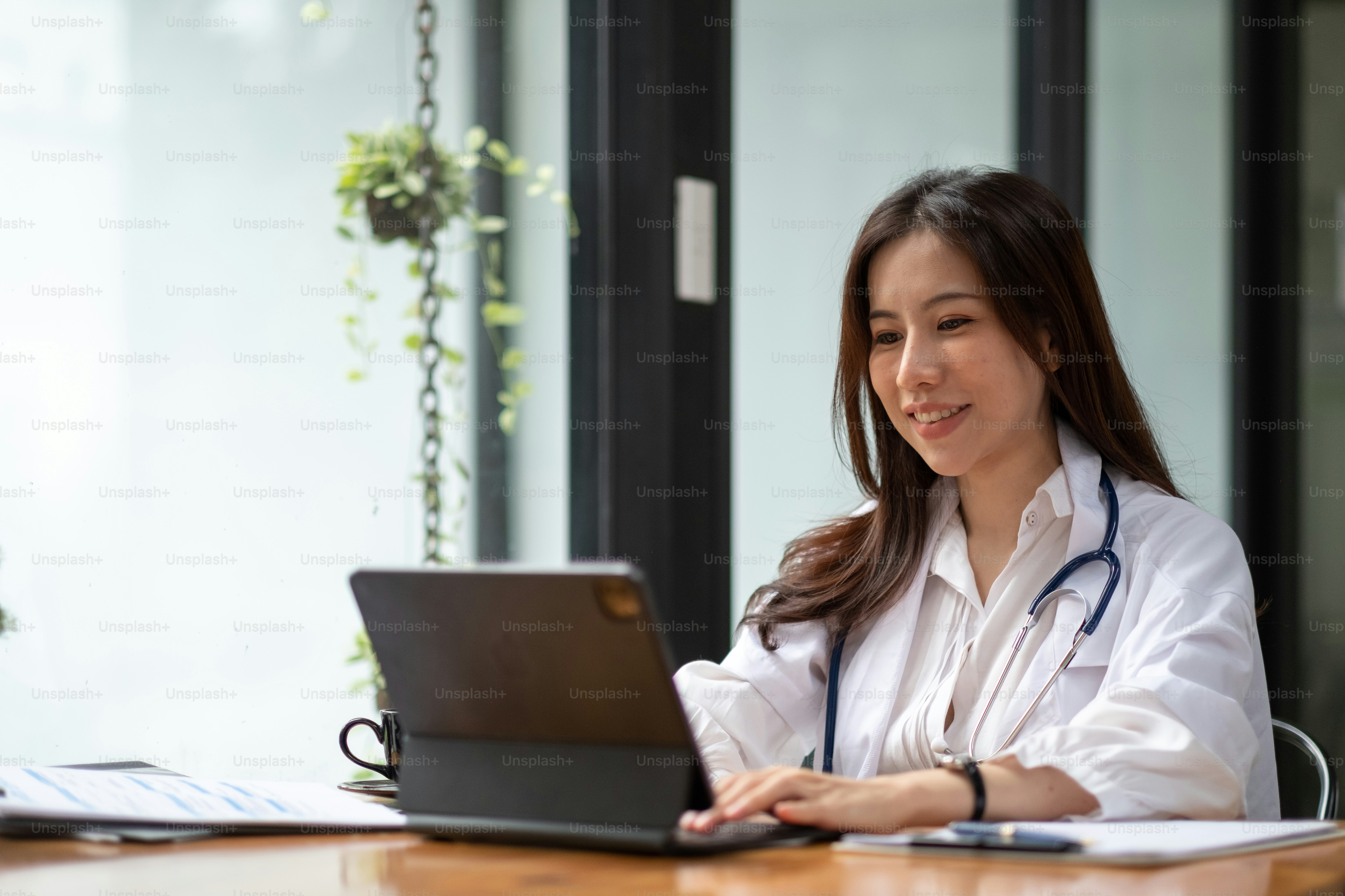 Portrait happy asian woman doctor, Telemedicine concept. Asian female doctor talking with patient using laptop online video webinar consultation while sitting in clinic office.