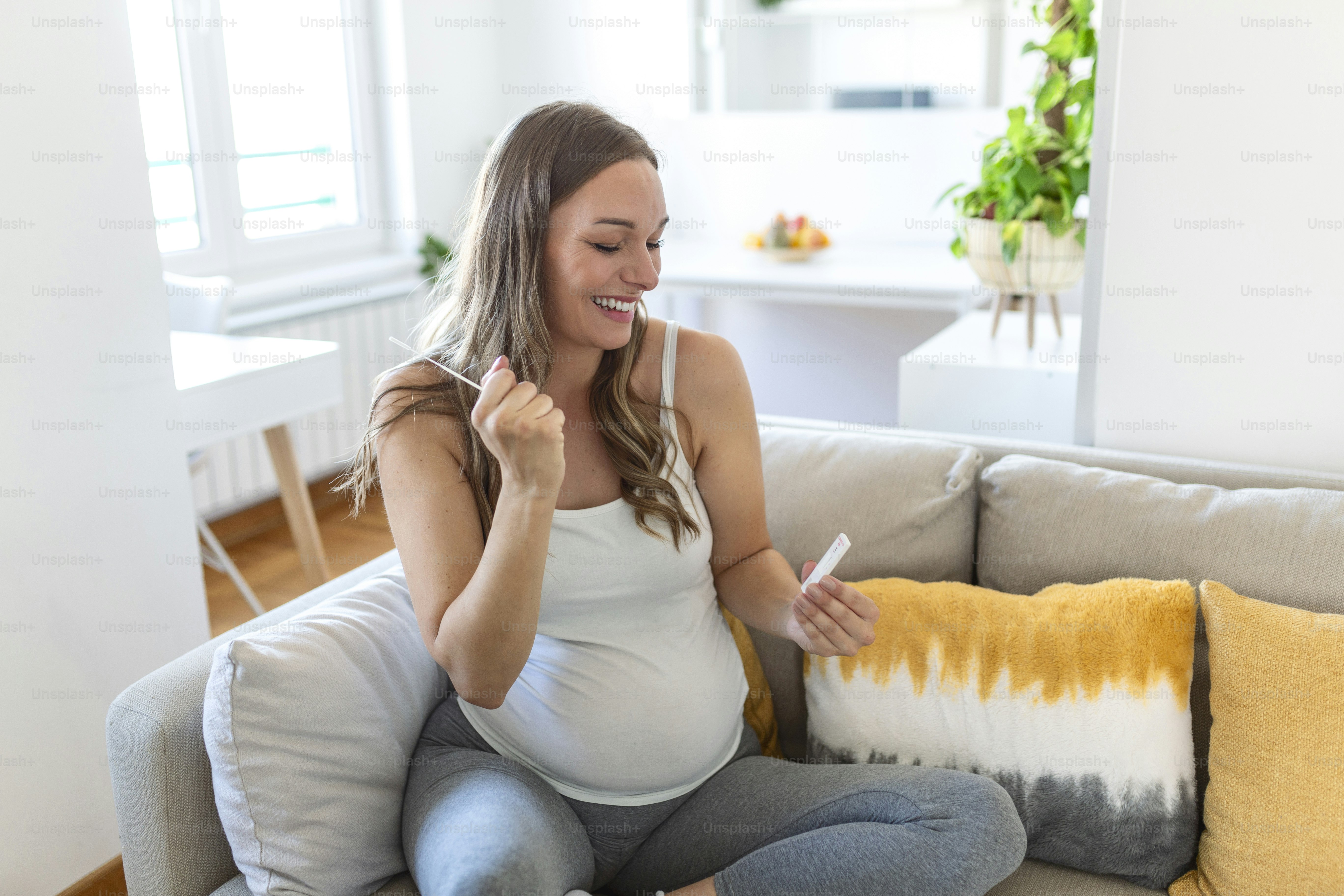 Close-up shot of Pregnant woman's hand holding a negative test device. Happy Pregnant woman showing her negative Coronavirus - Covid-19 rapid test. Coronavirus