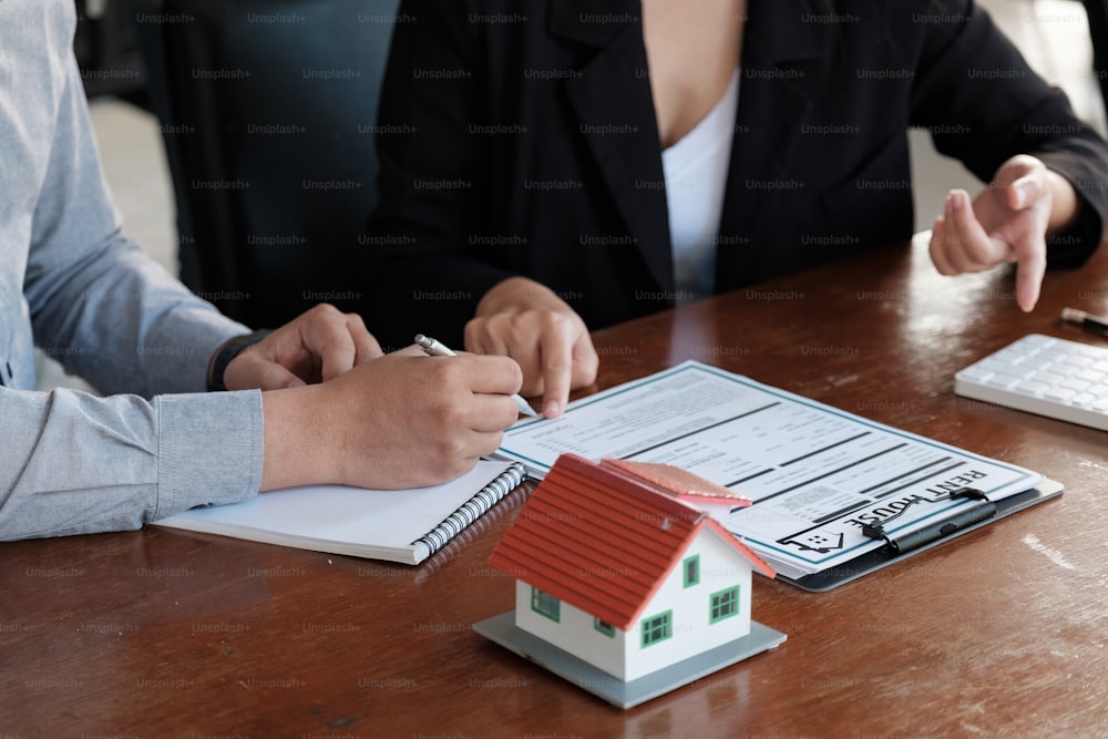 Immobilienmakler sprach über die Bedingungen des Hauskaufvertrags, Kunden unterzeichnen die Dokumente, um den Vertrag legal zu machen, Hausverkauf und Hausversicherungskonzept.