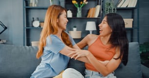 Happy Asian women teenager visit her close friends cuddling smiling at home. Overjoyed excited best buddies embracing hugging, greeting each other with success, true strong friendship.
