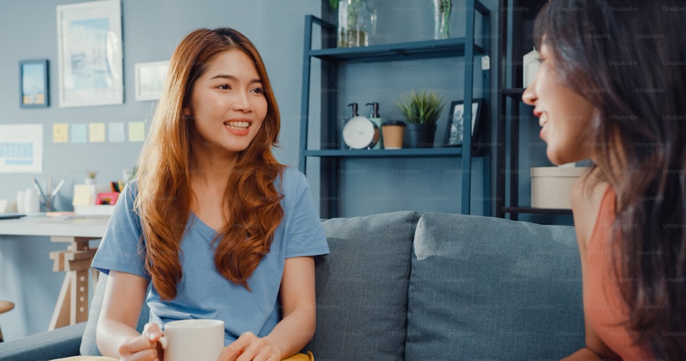 Les femmes au foyer asiatiques se détendent occasionnellement sur le canapé avec une tasse de thé parlent ensemble de leur vie et des potins de leur relation avec le mari dans le salon de la maison.