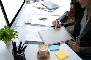 Donna d'affari che utilizza la tavoletta digitale in un ufficio moderno.