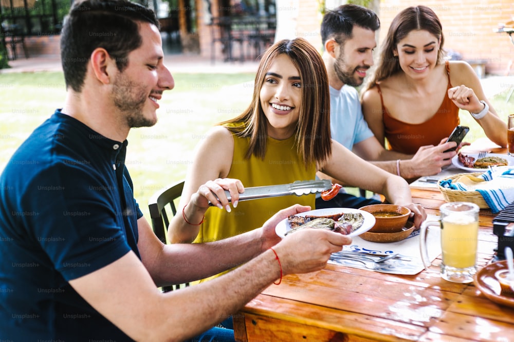 Grupo de amigos latinos comendo comida mexicana no terraço do restaurante no México América Latina