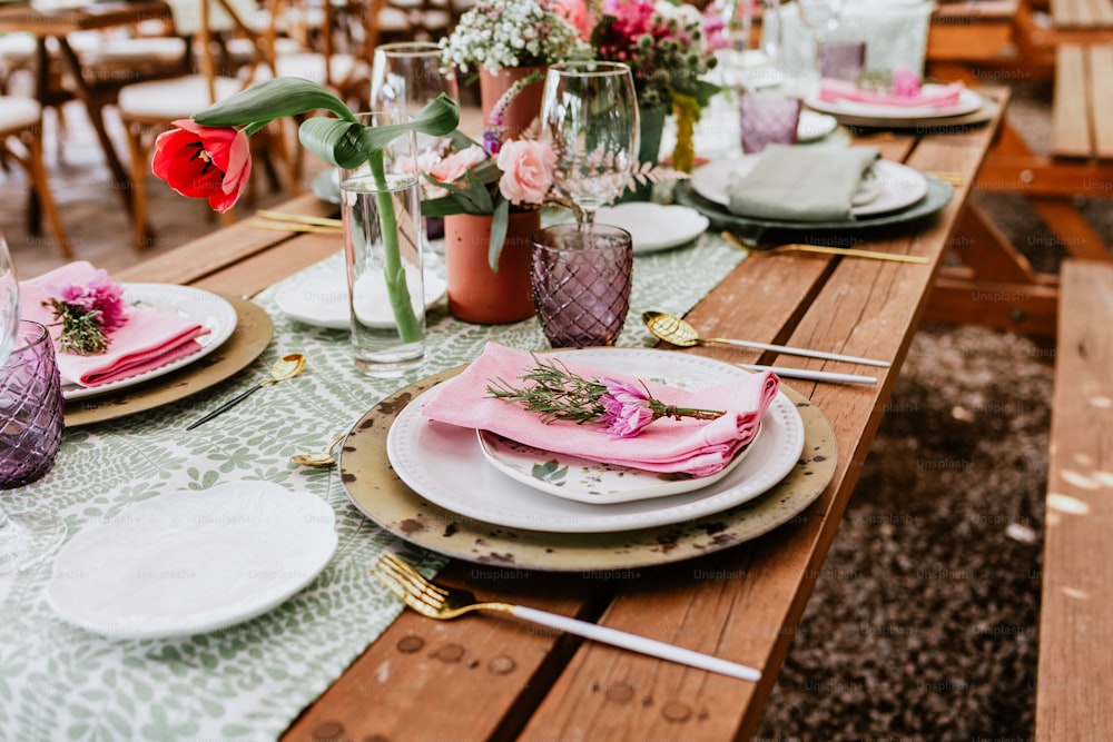 테라스에서 결혼식 피로연을 위해 장식된 테이블에 꽃, 안경 및 접시가 있는 테이블 설정 라틴 아메리카