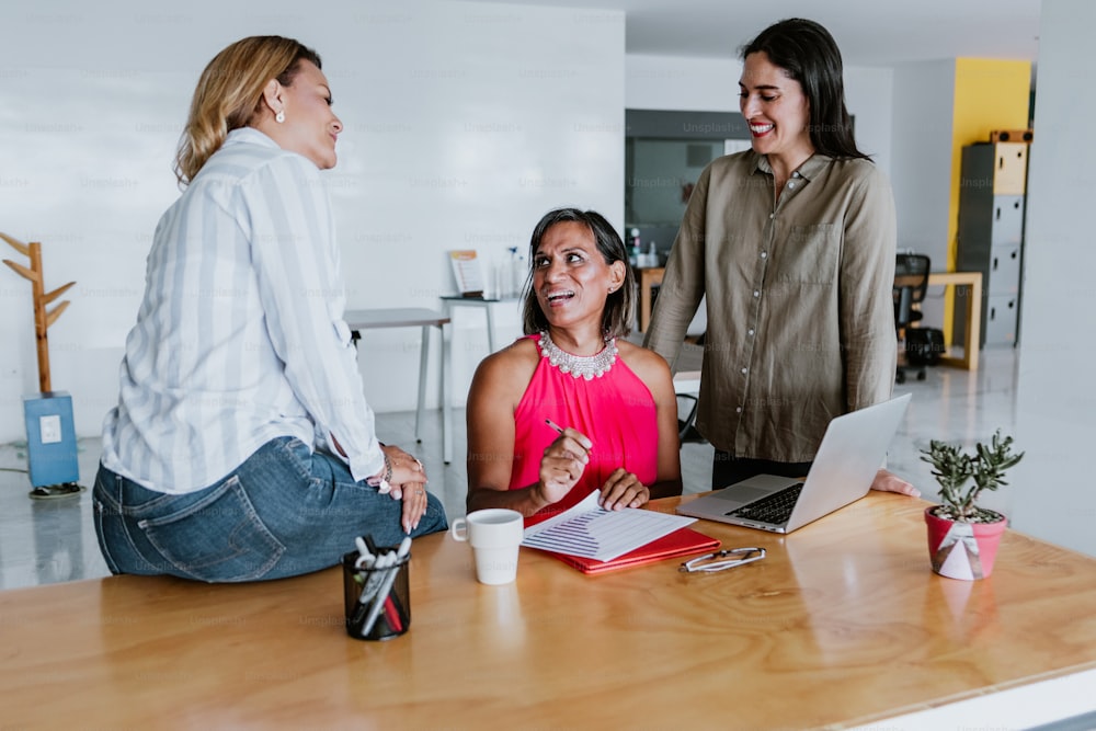 transgender latin woman working with woman coworkers at the office in Mexico Latin America