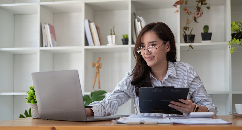 Close up accounting woman working for financial report with laptop and calculator.