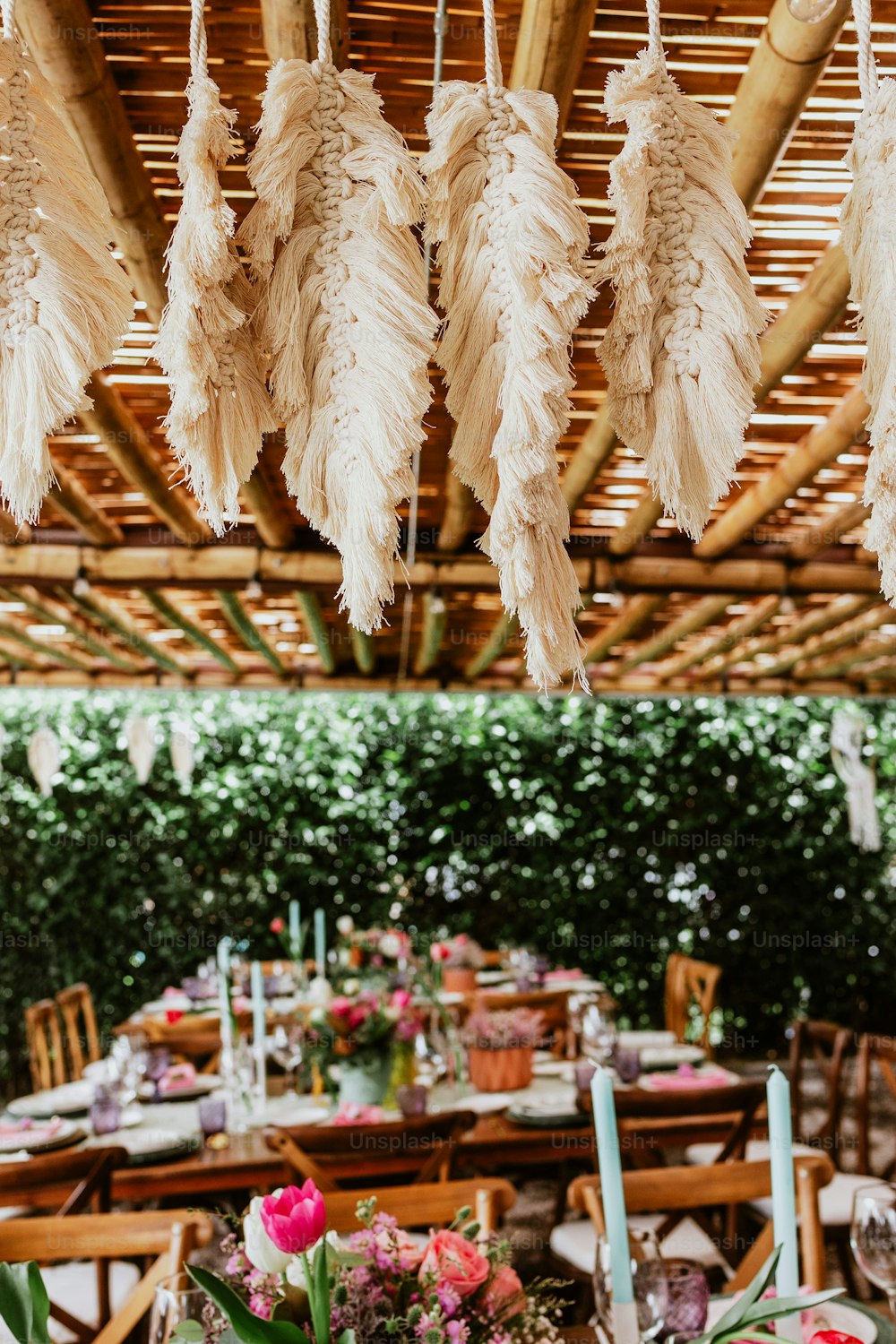 terrasse avec des tables dressées avec des fleurs et des assiettes sur table décorées pour la réception de mariage en Amérique latine