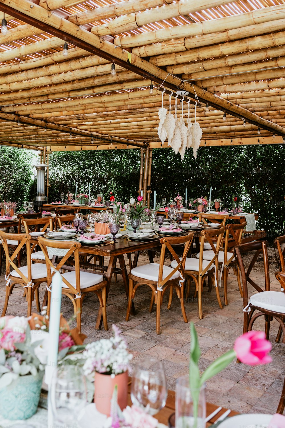 Terrasse mit Tischen mit Blumen und Tellern auf Tisch dekoriert für Hochzeitsempfang in Lateinamerika