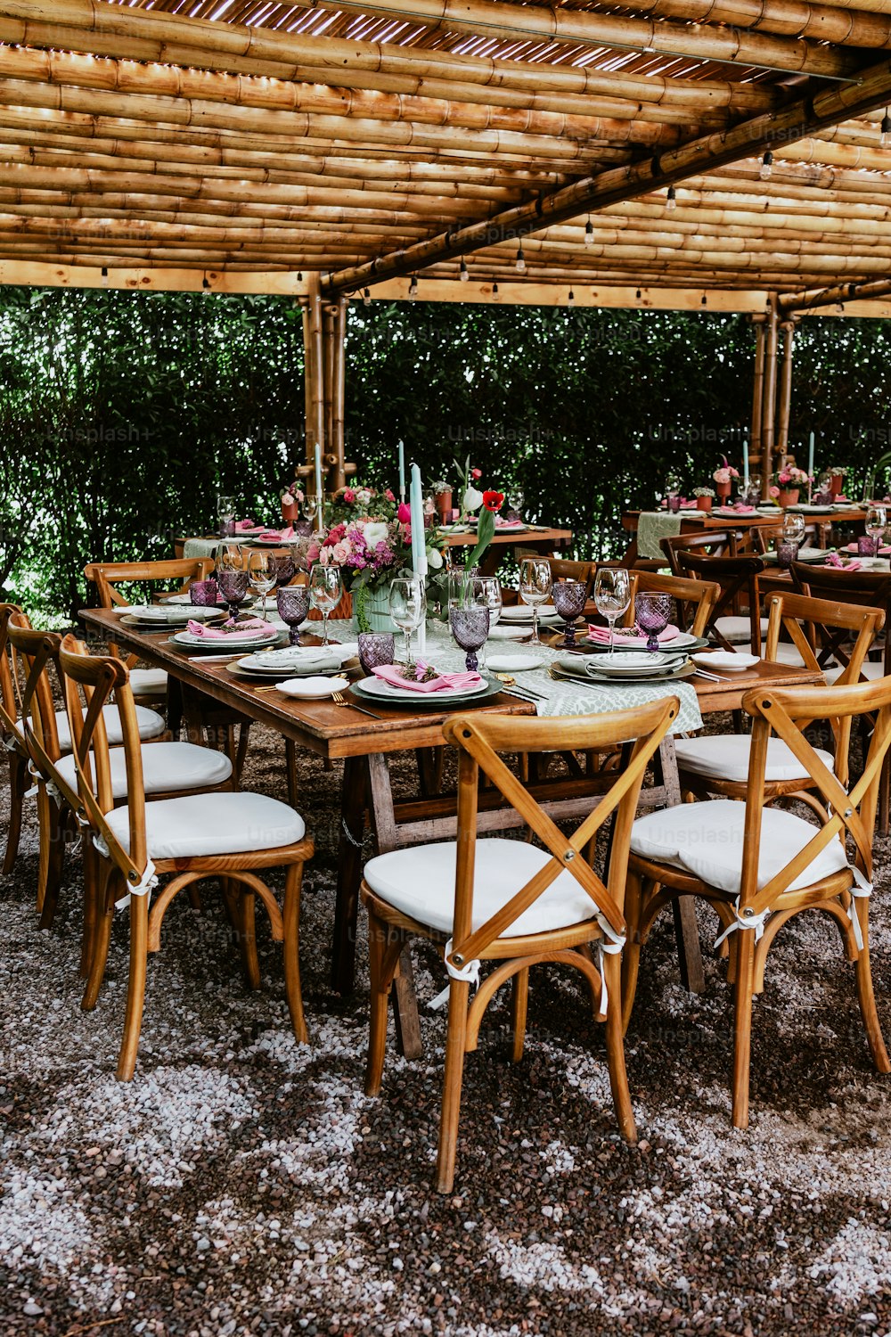 ラテンアメリカでの結婚披露宴のために飾られたテーブルの上に花と皿が置かれたテーブルのあるテラス
