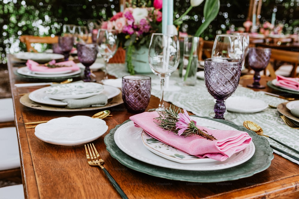 テラスラテンアメリカでの結婚披露宴のために飾られたテーブルの上に花、グラス、プレートを備えたテーブルセットアップ