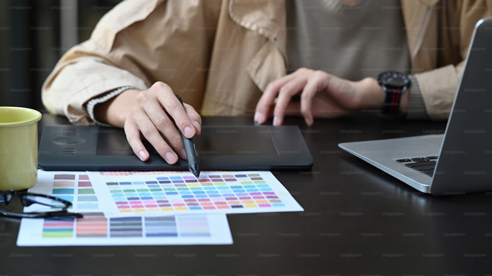 Cropped shot graphic designer choosing color from color swatches.