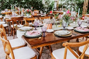 terrace with tables setup with flowers and plates on table decorated for Wedding Reception in Latin America