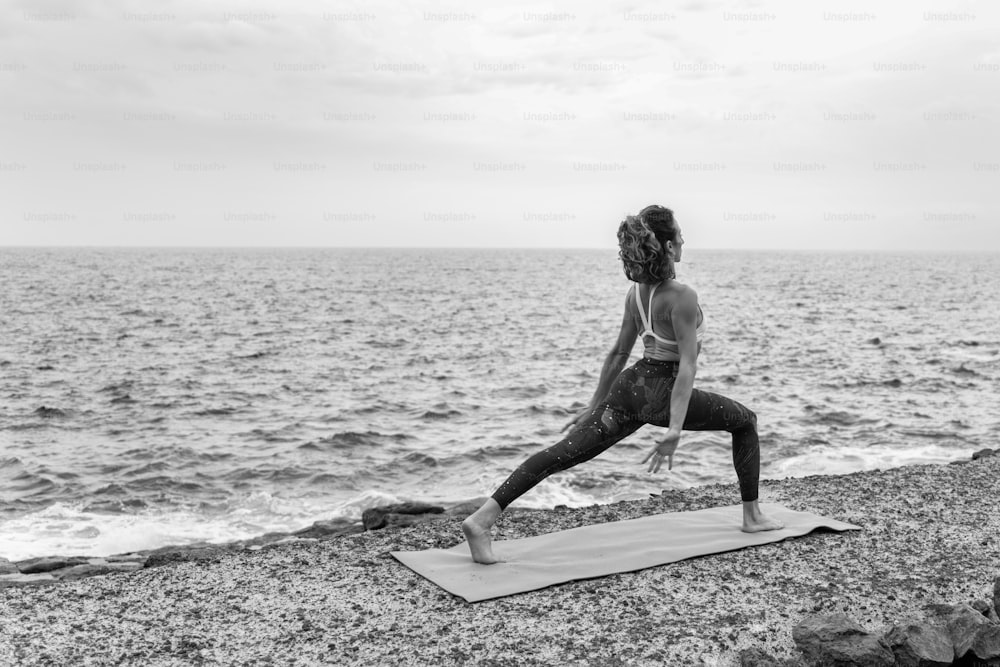 Mujer deportiva activa de pie en postura de yoga en la costa. Rutina matutina. Ejercicio de la respiración. Atención plena.