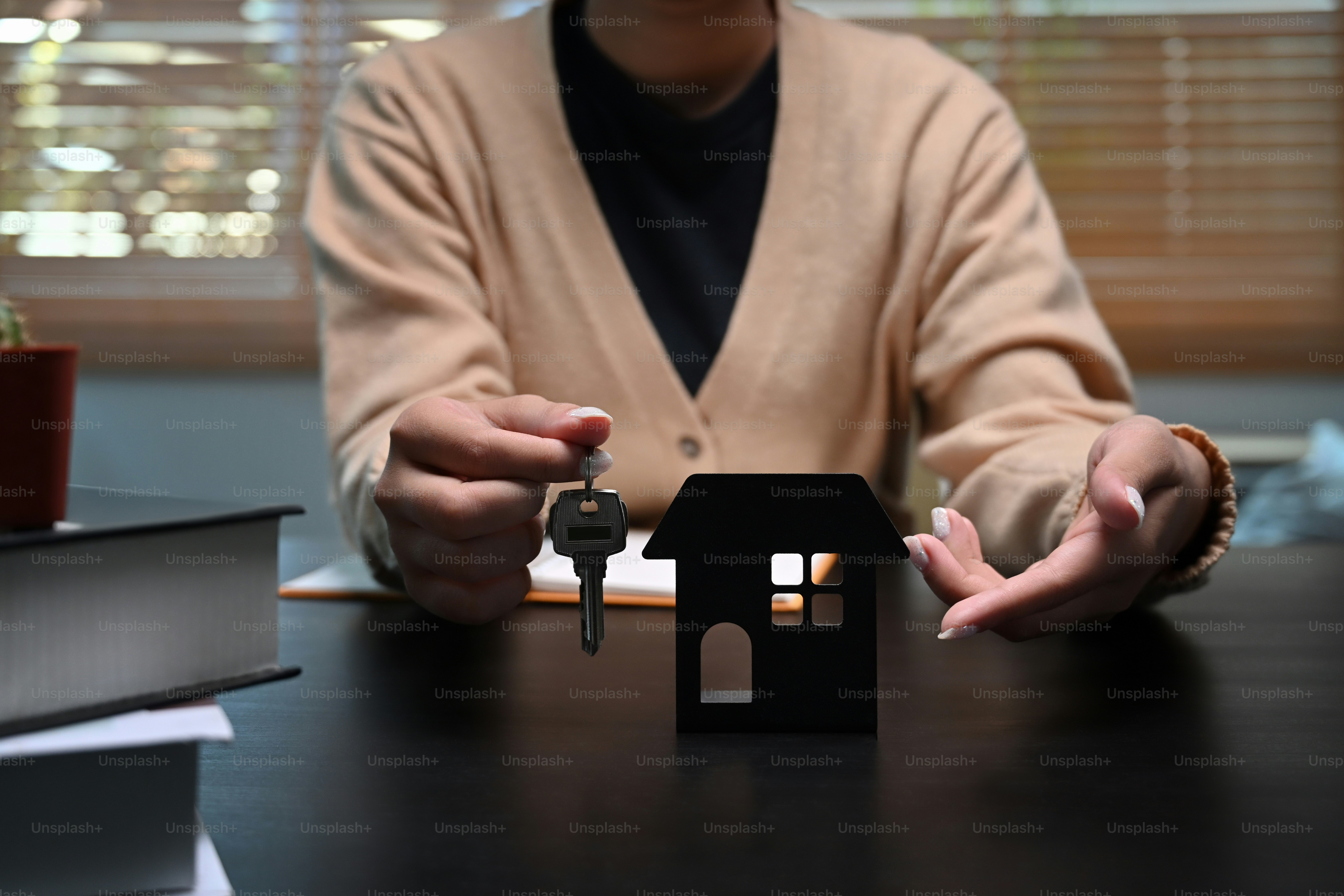 Cropped image of woman holding house keys. Mortgage and real estate investment concept.