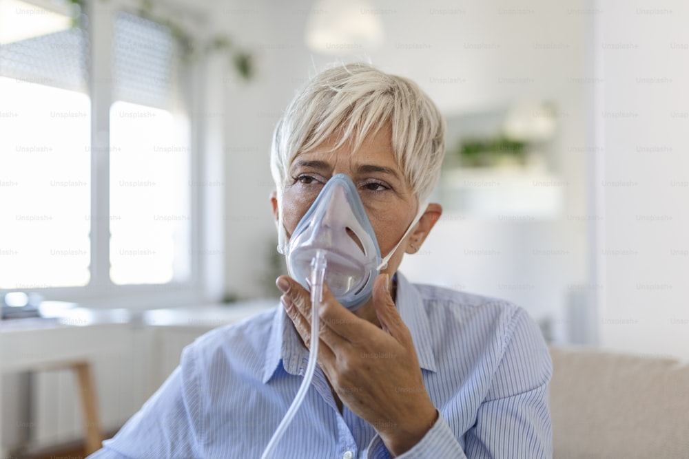 Sick elderly woman on oxygen mask inhalation, pneumonia coronavirus pandemic. ill senior woman wearing an oxygen mask and undergoing treatment. senior woman with covid 19